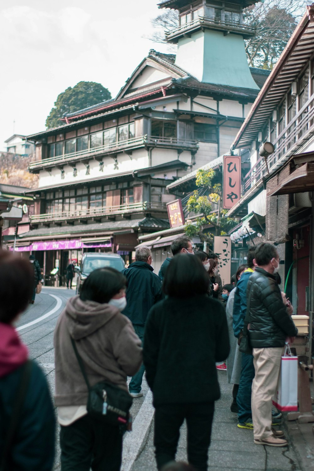 Un grupo de personas caminando por una calle junto a edificios altos