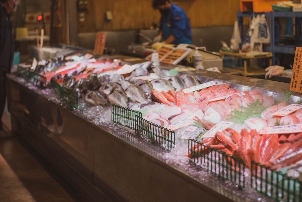 a man standing in front of a counter filled with seafood