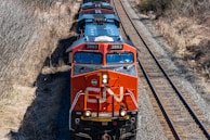a train traveling down train tracks next to a forest