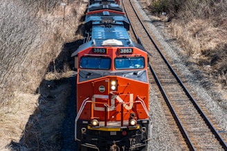 a train traveling down train tracks next to a forest