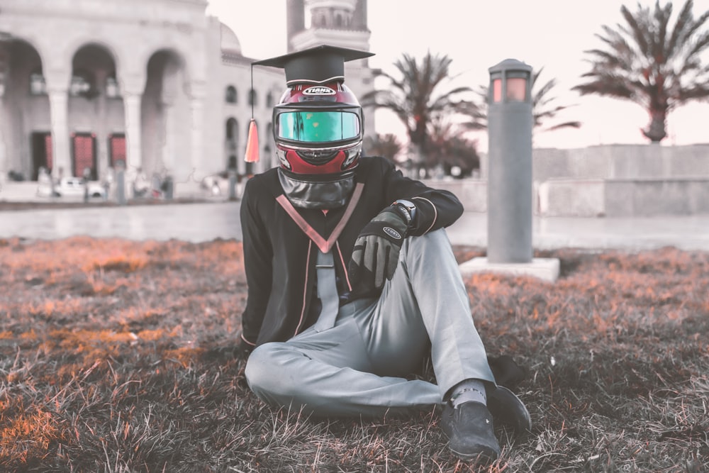 a person sitting on the ground wearing a helmet