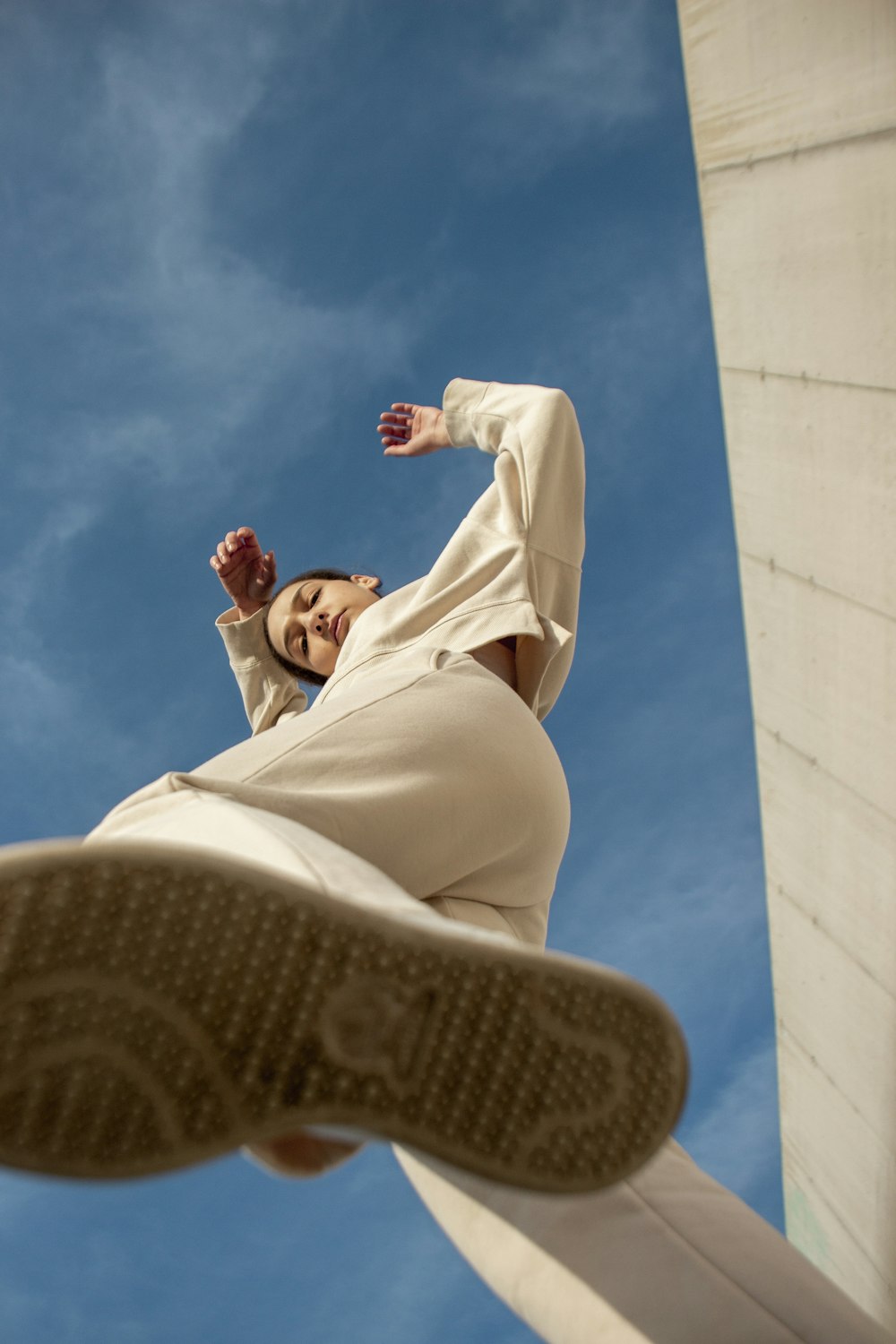 a woman in a white dress is doing a trick