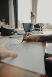 a person is drawing on a piece of paper