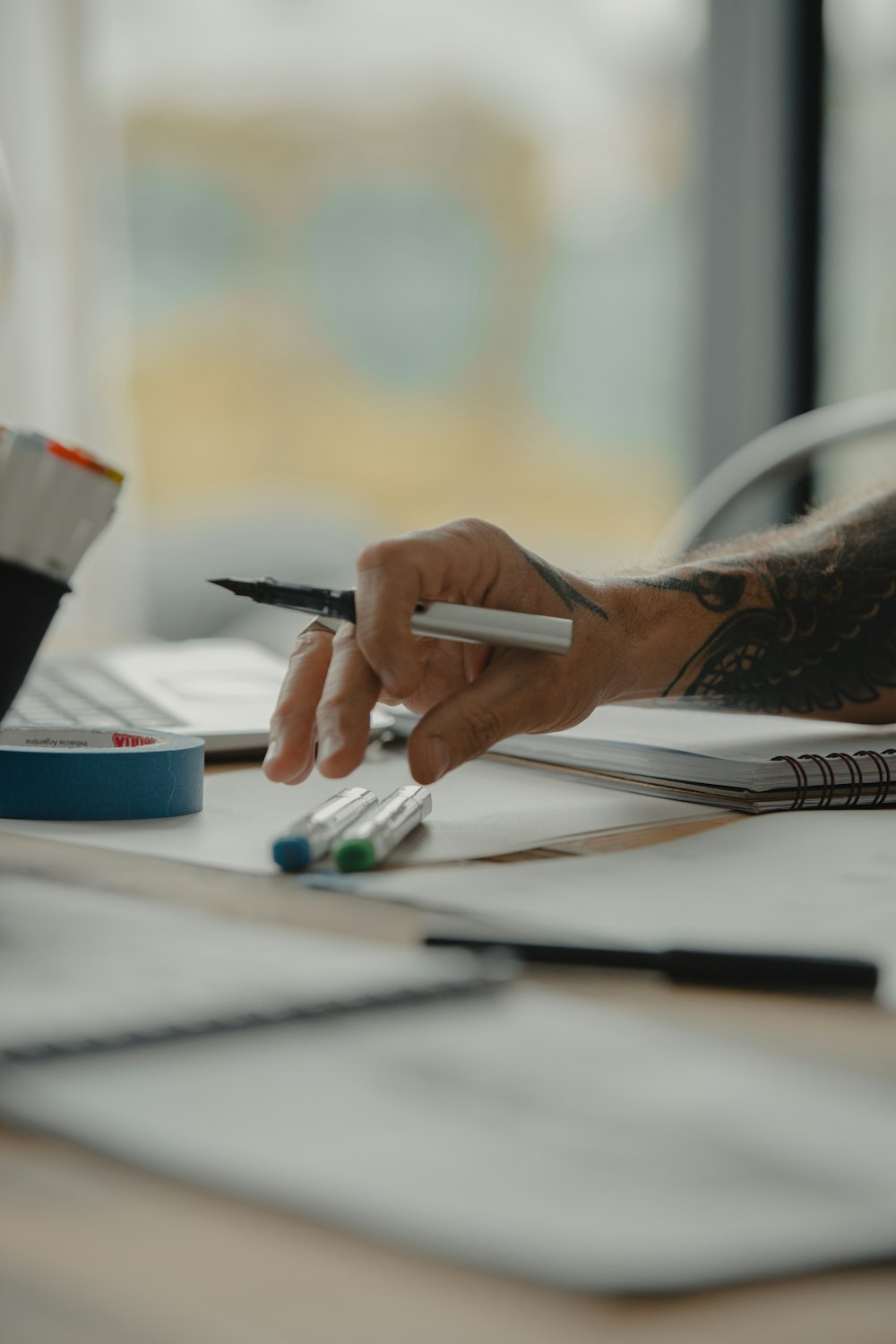 a person writing on a piece of paper with a pen