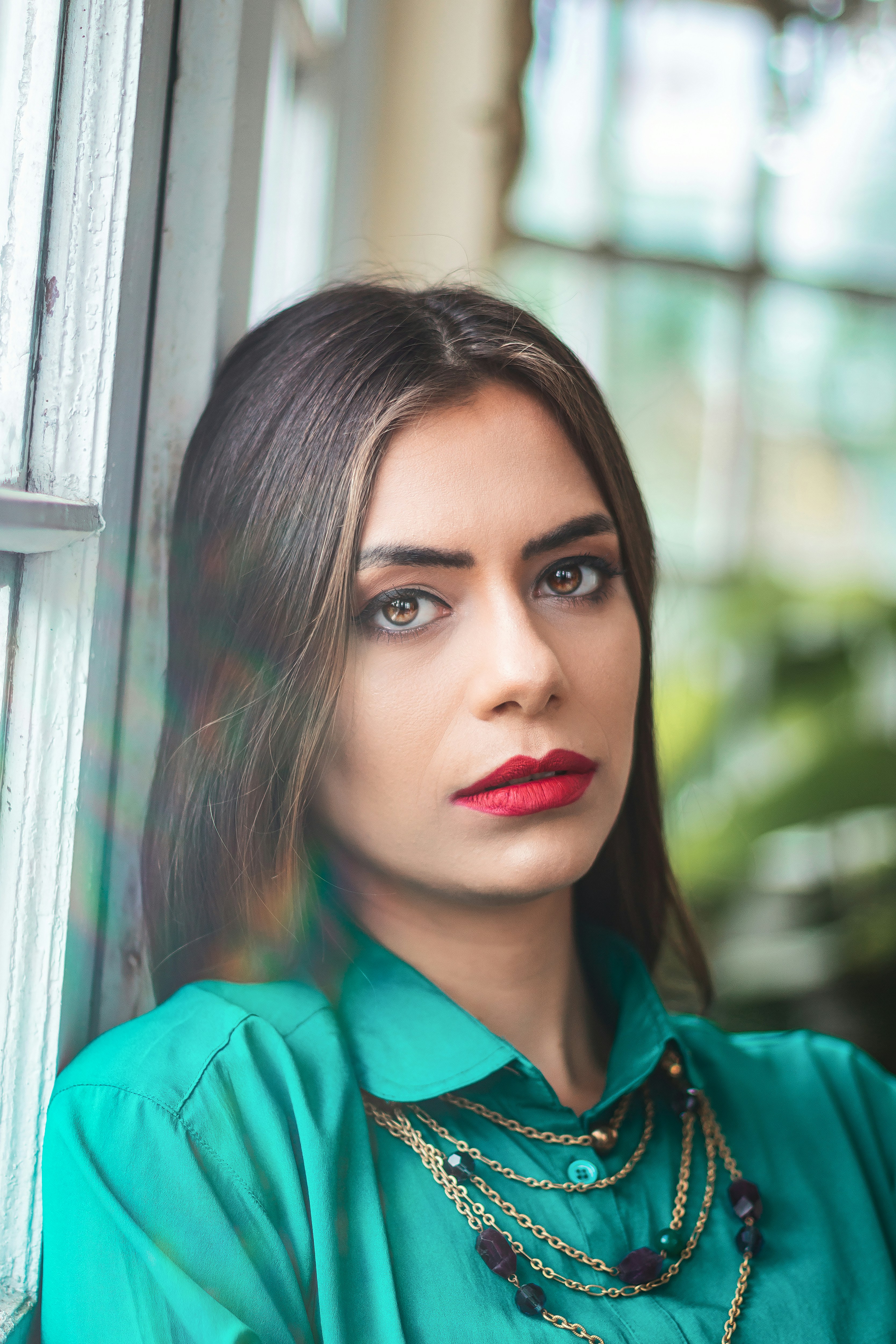 a woman wearing a green shirt and a necklace