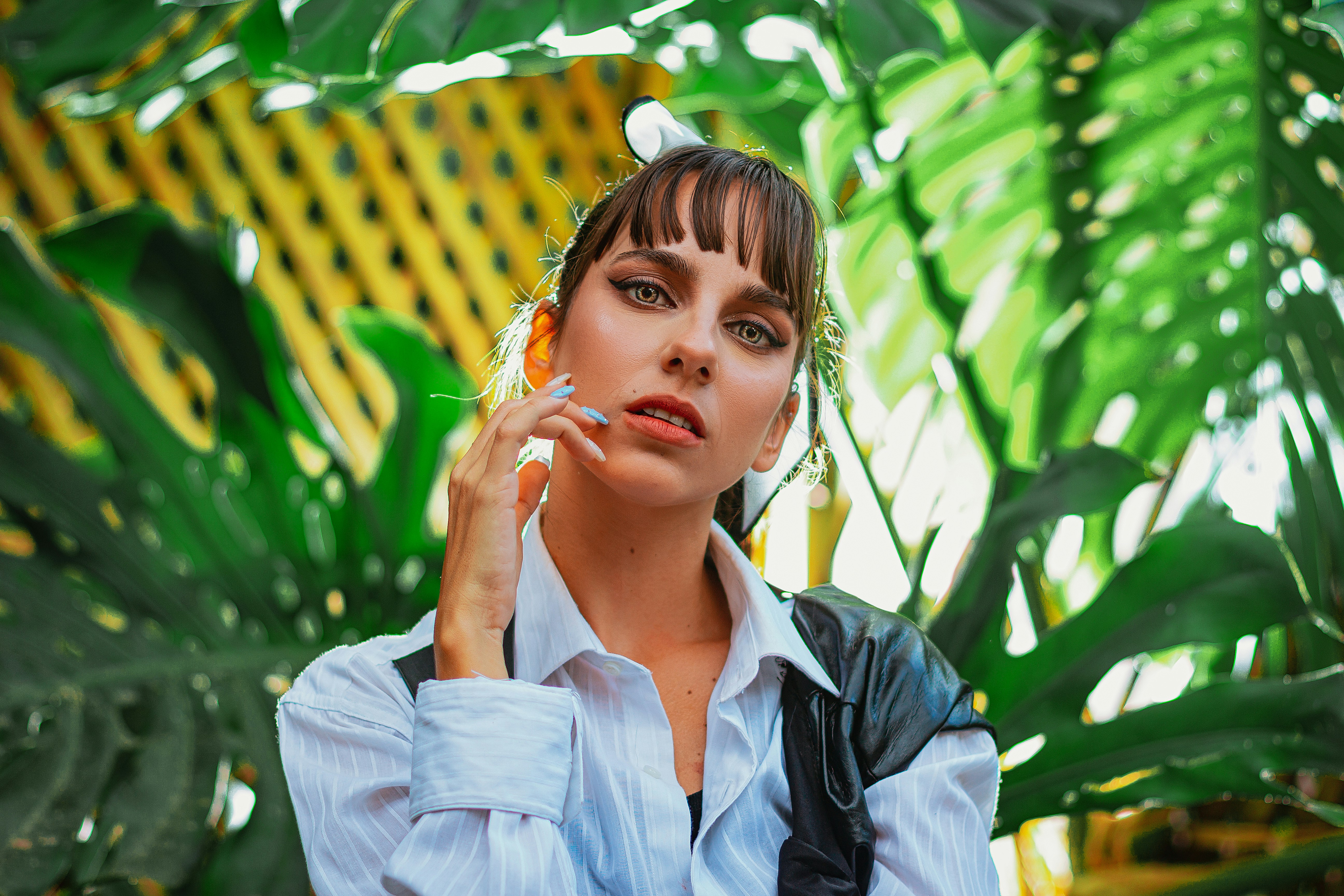 a woman standing in front of a green plant
