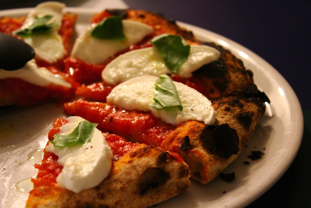 a pizza with mozzarella and basil on a plate