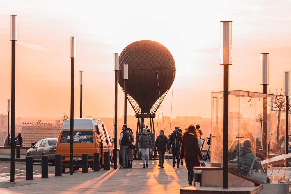 a group of people walking down a sidewalk next to a water tower