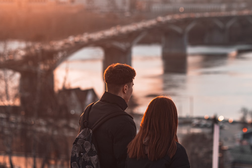 a man and a woman looking at a bridge
