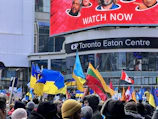 A vibrant community event welcoming new Canadian immigrants with flags and smiles.