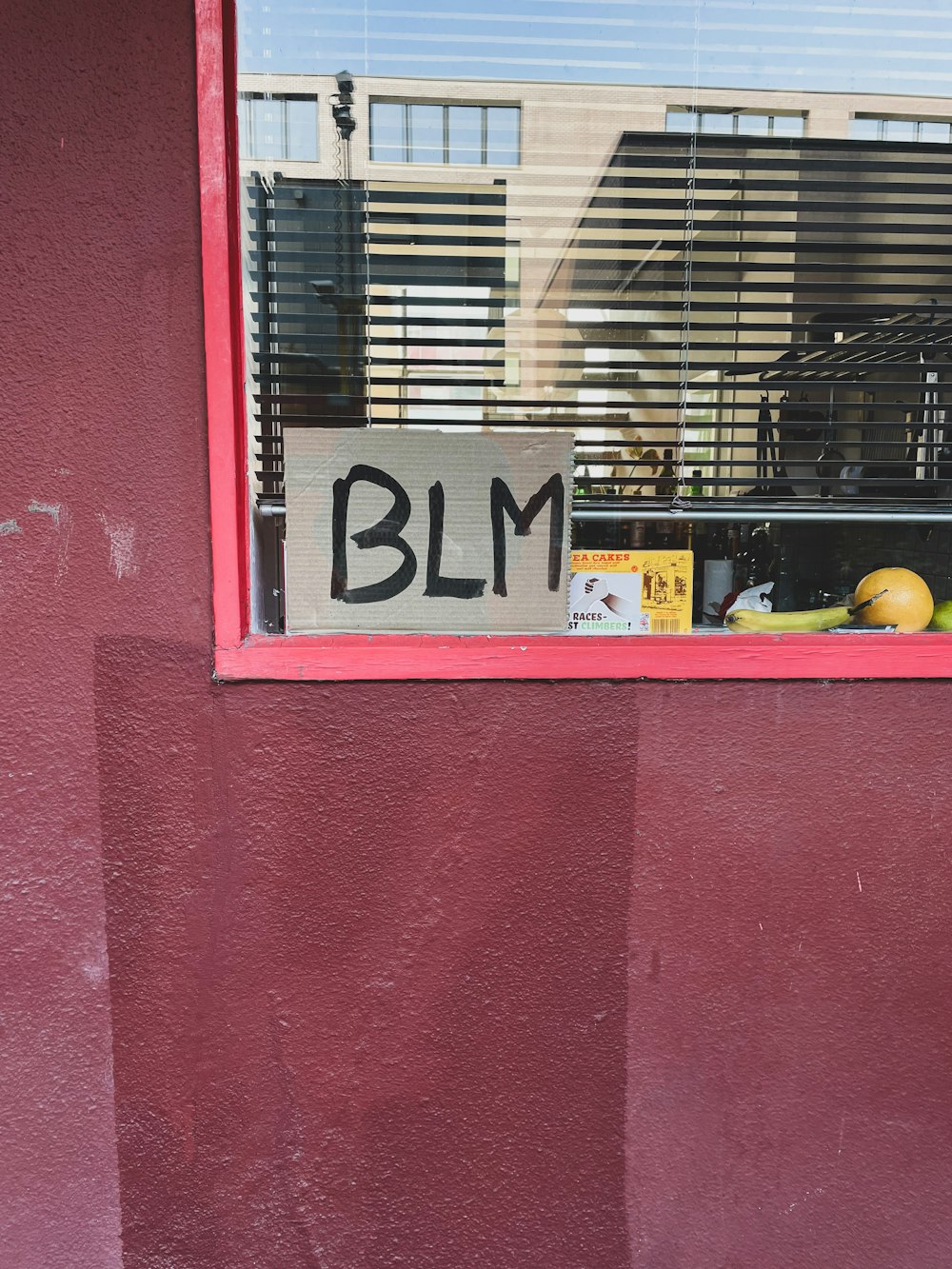 a sign that says blm in front of a window