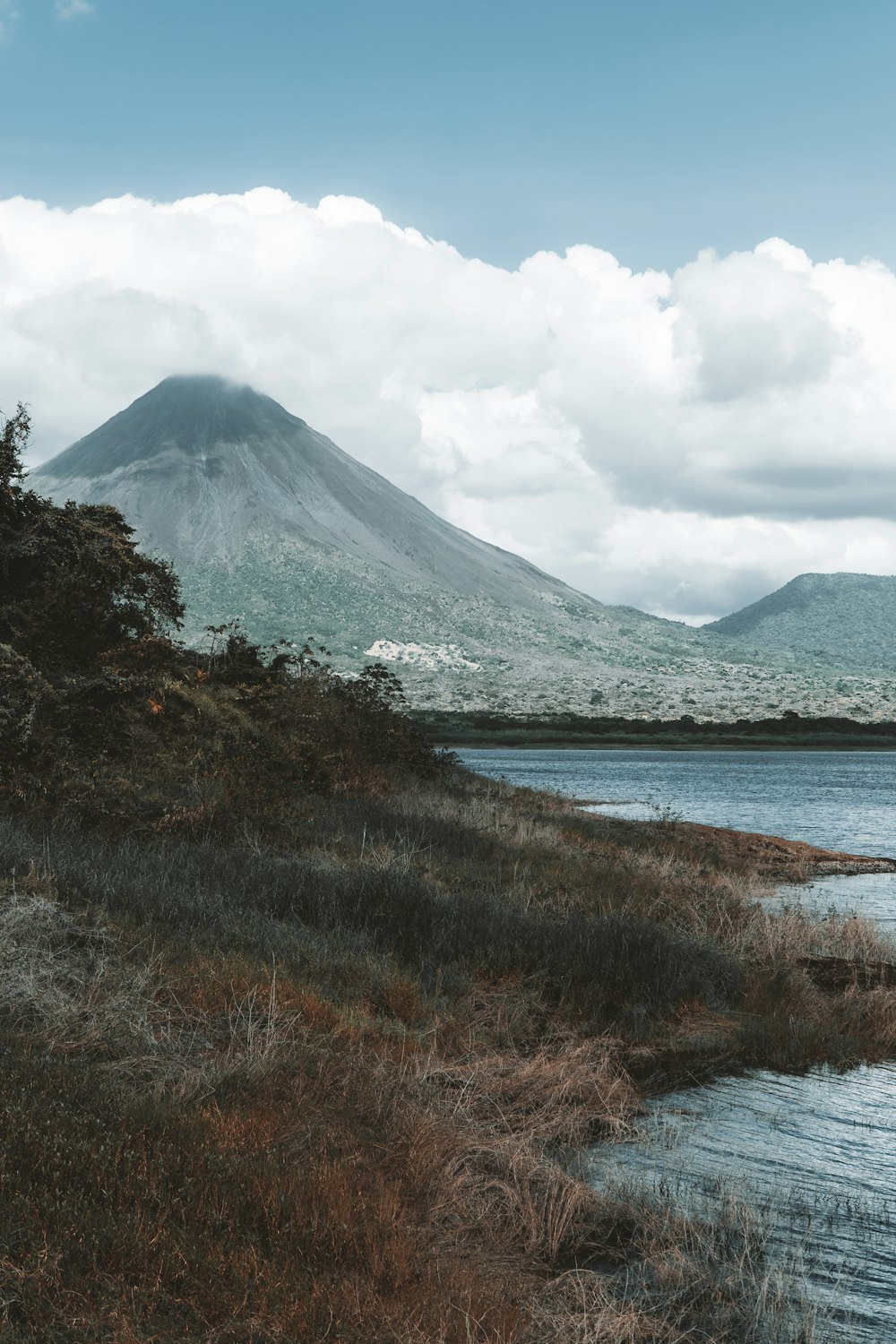 a large body of water with a mountain in the background