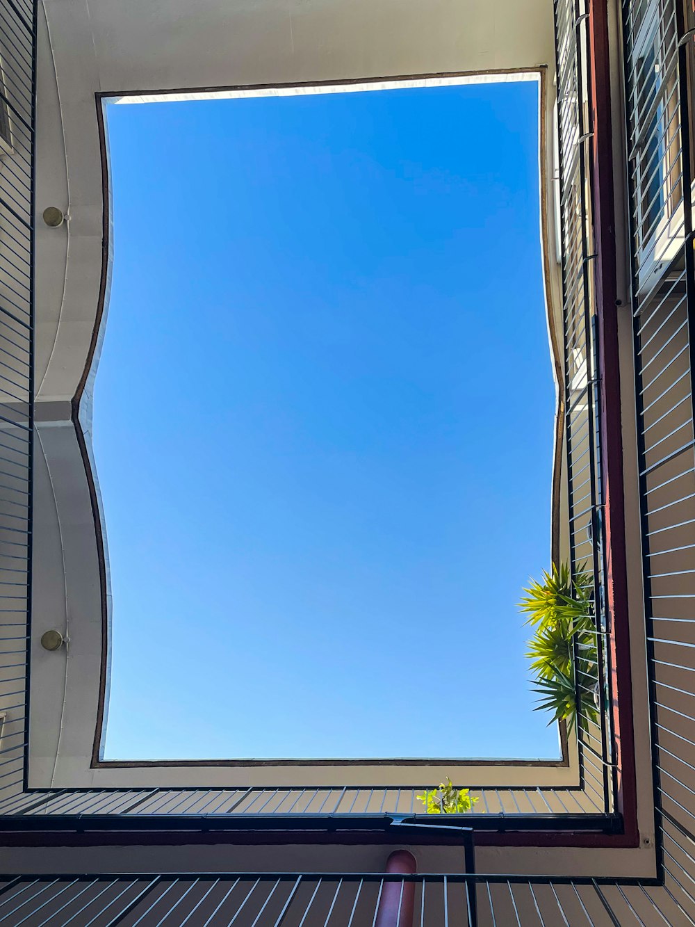 Blick in den blauen Himmel durch ein Fenster