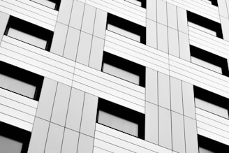 Minimalist building facade with sharp black and cyan geometric patterns.