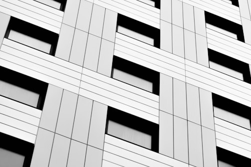 Minimalist building facade with sharp black and cyan geometric patterns.