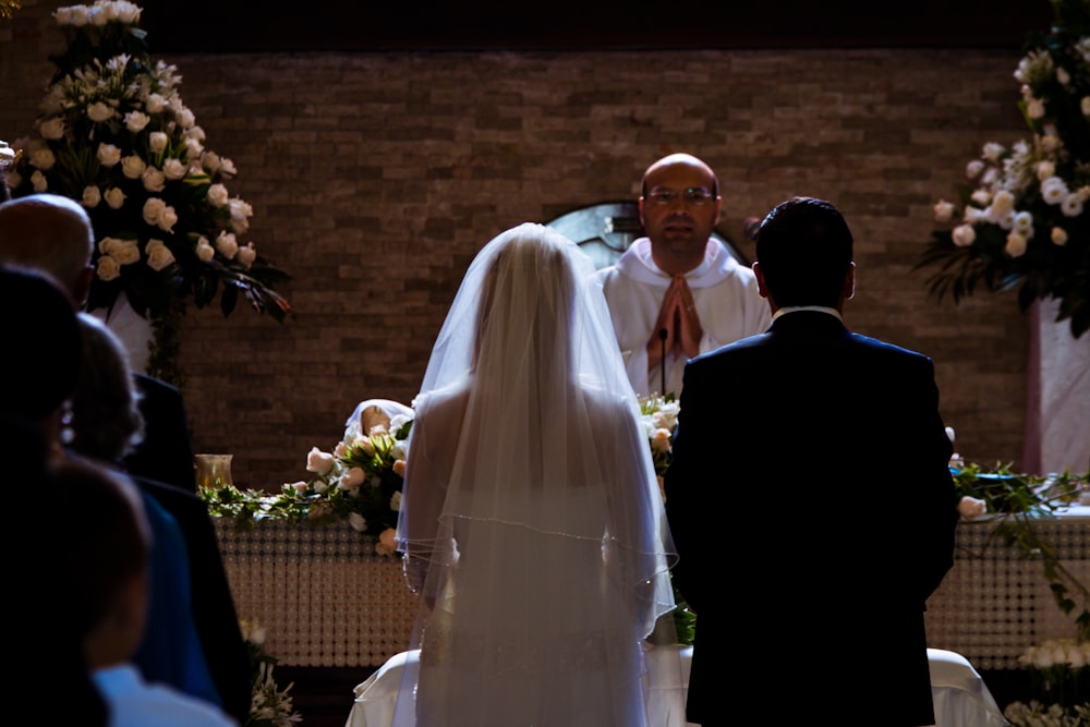a bride and groom standing at the alter of a church