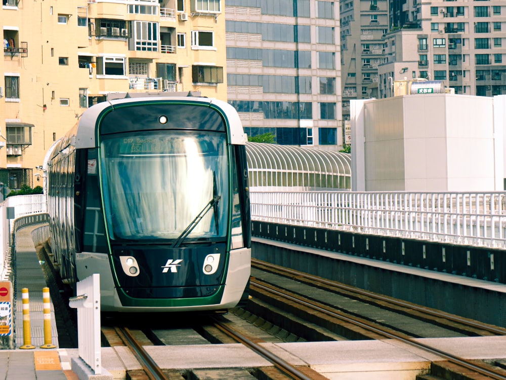 a train traveling down tracks next to tall buildings