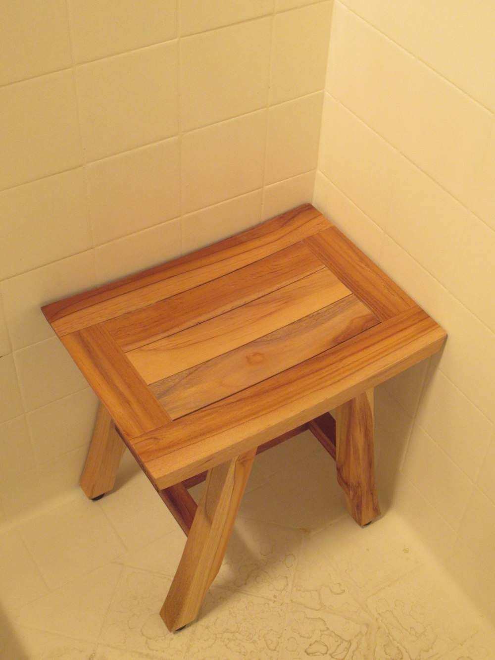 a small wooden table sitting in a bathroom