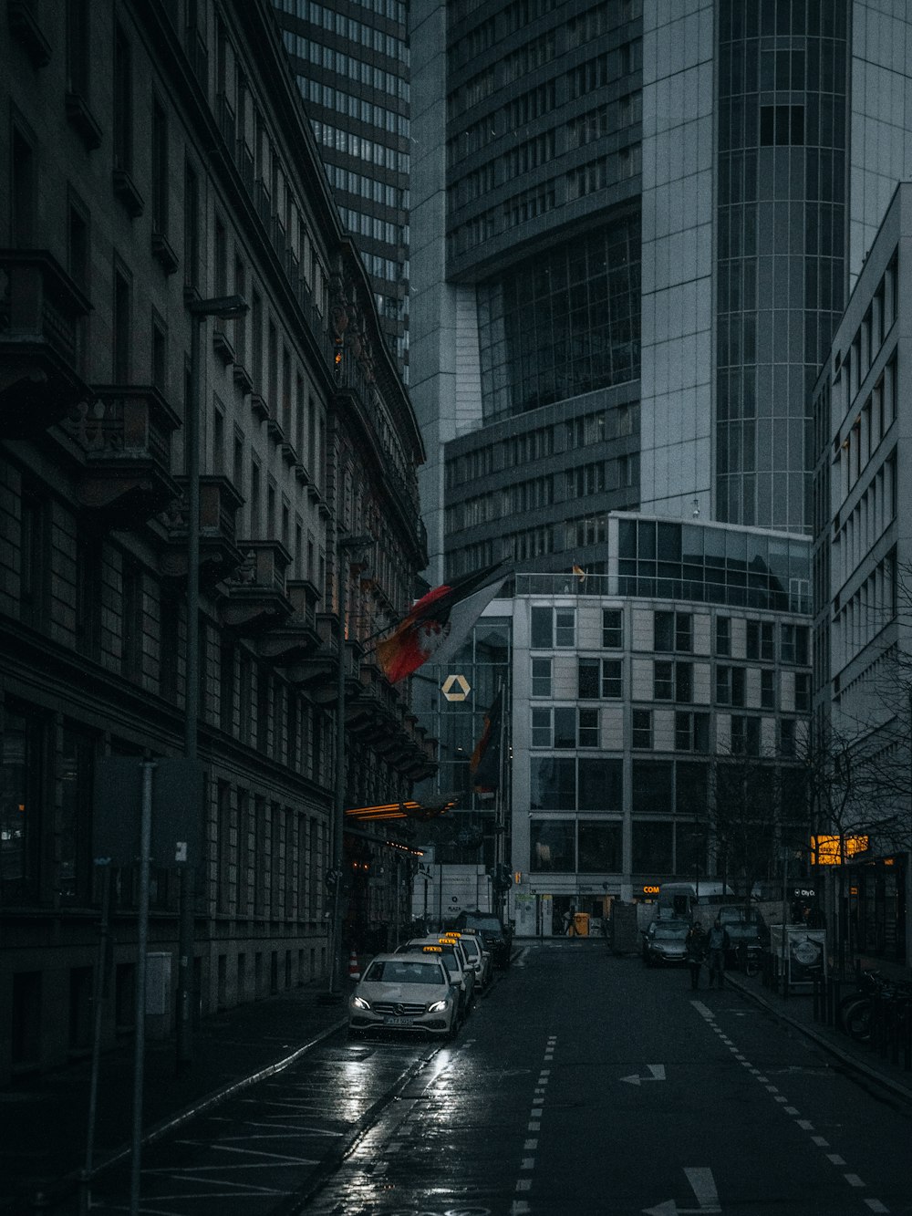 a dark city street with tall buildings on both sides