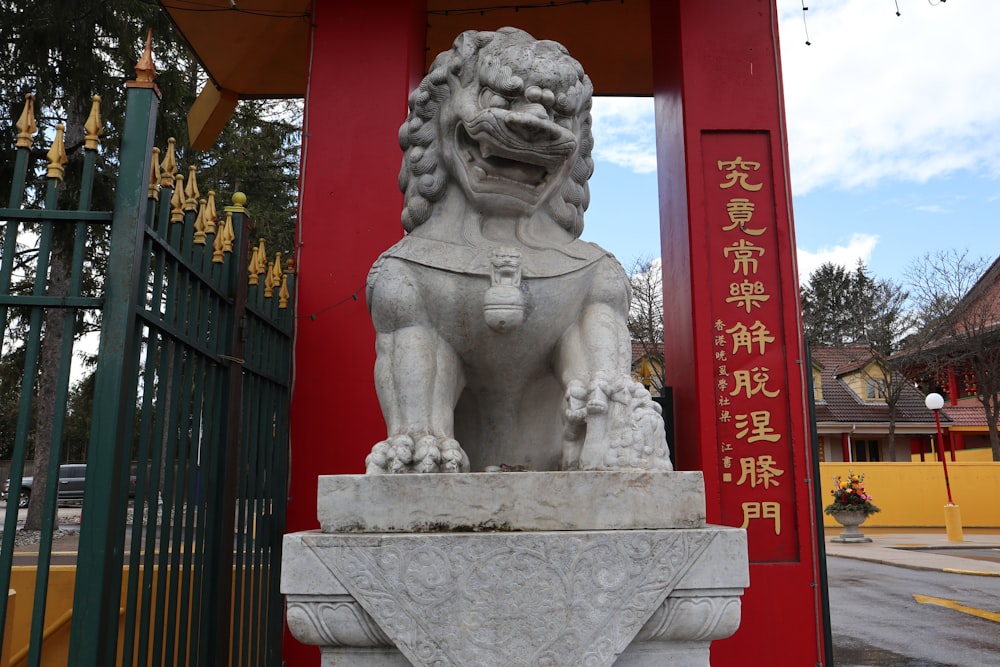 a statue of a lion in front of a gate