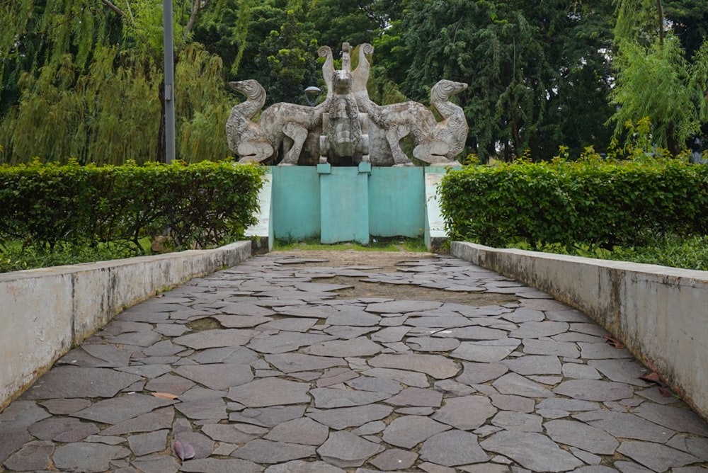 a stone walkway with a statue of birds on top of it
