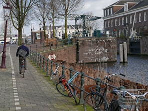 a man riding a bike down a street next to a river