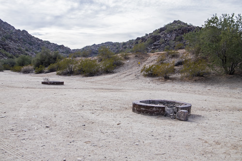 a couple of benches sitting on top of a dirt field
