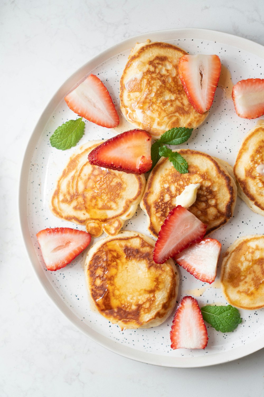 a white plate topped with pancakes and strawberries