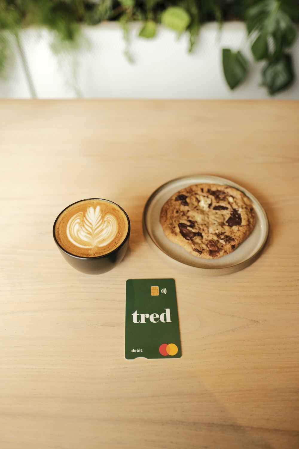 a cup of coffee and a cookie on a table