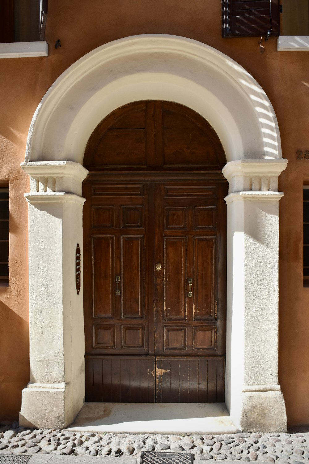 a large wooden door with a white arch