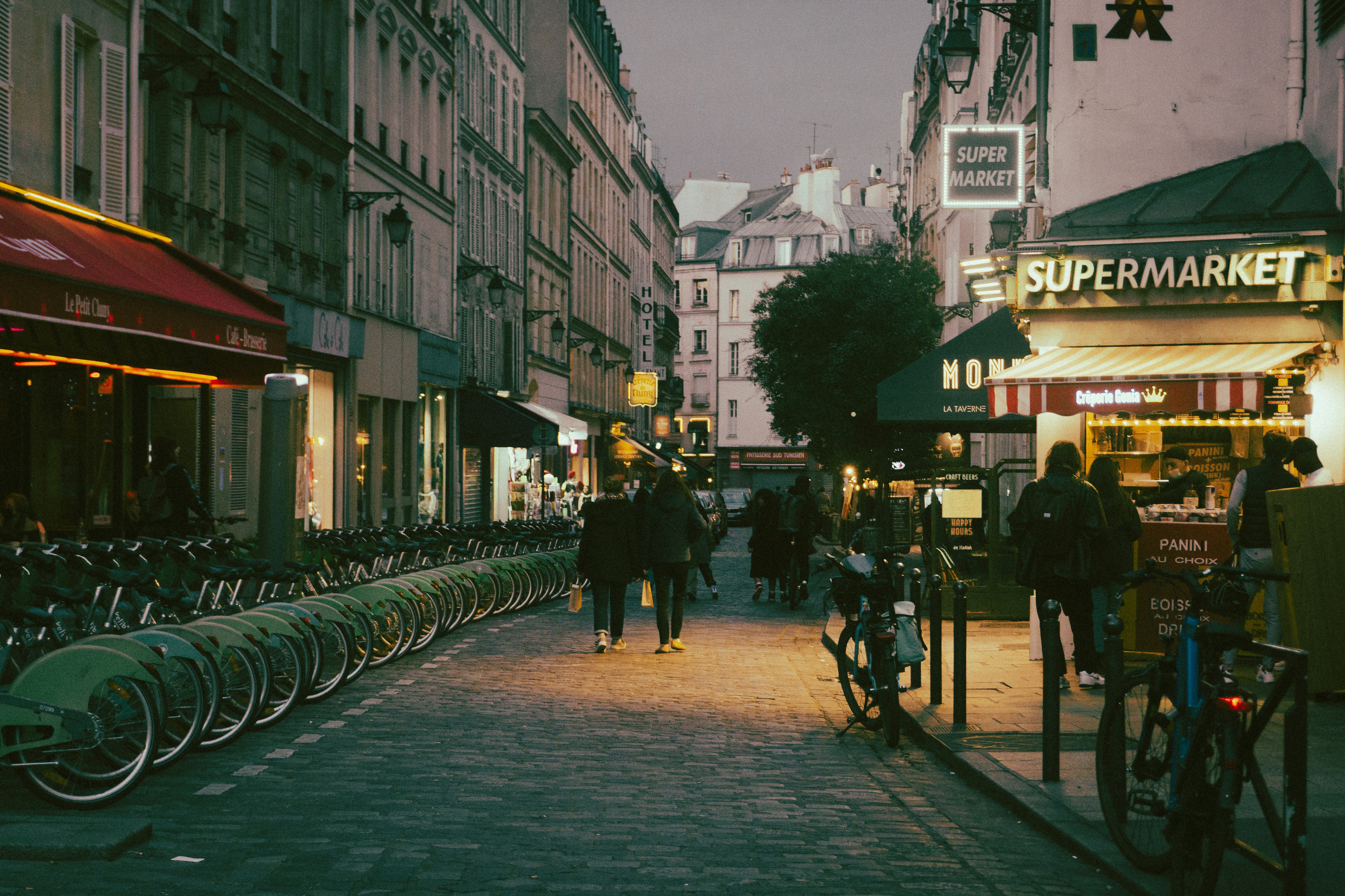 a city street lined with bicycles and people