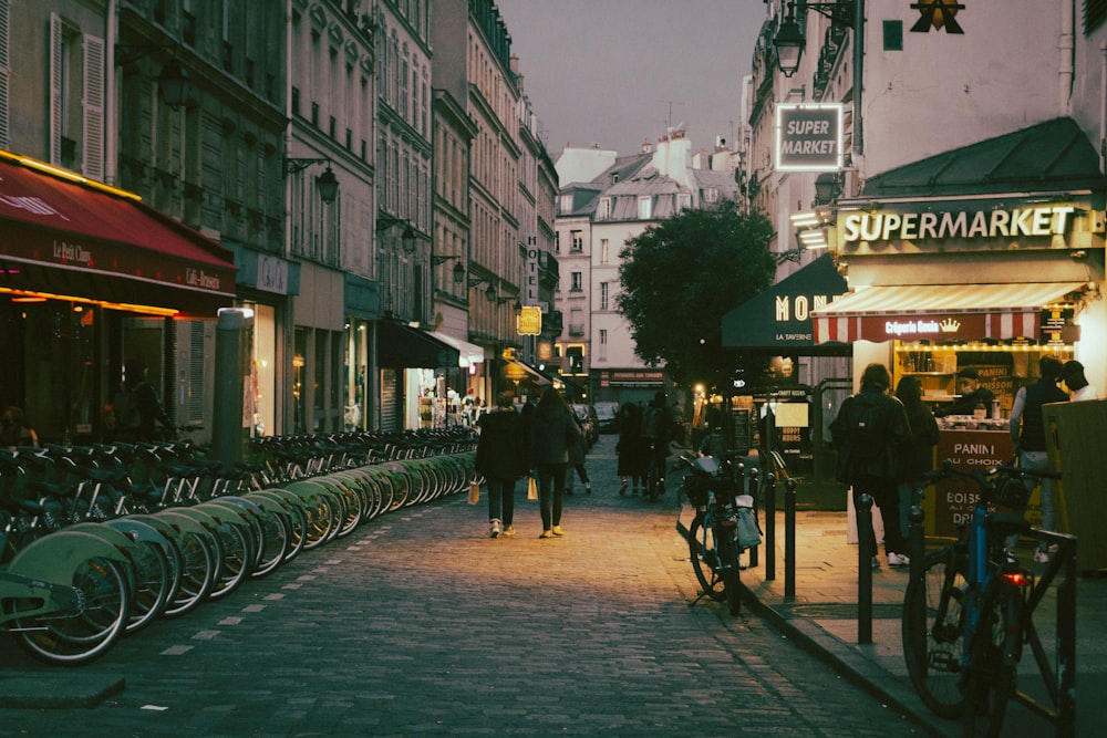 a city street lined with bicycles and people