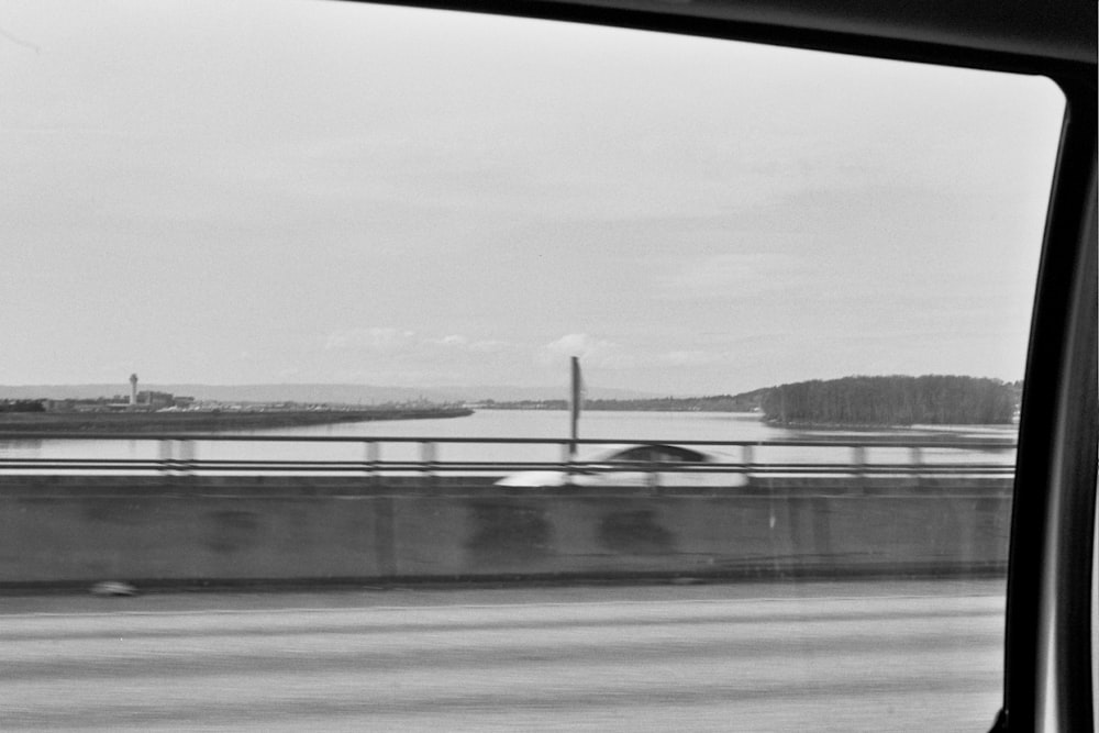 a black and white photo of a bridge and water