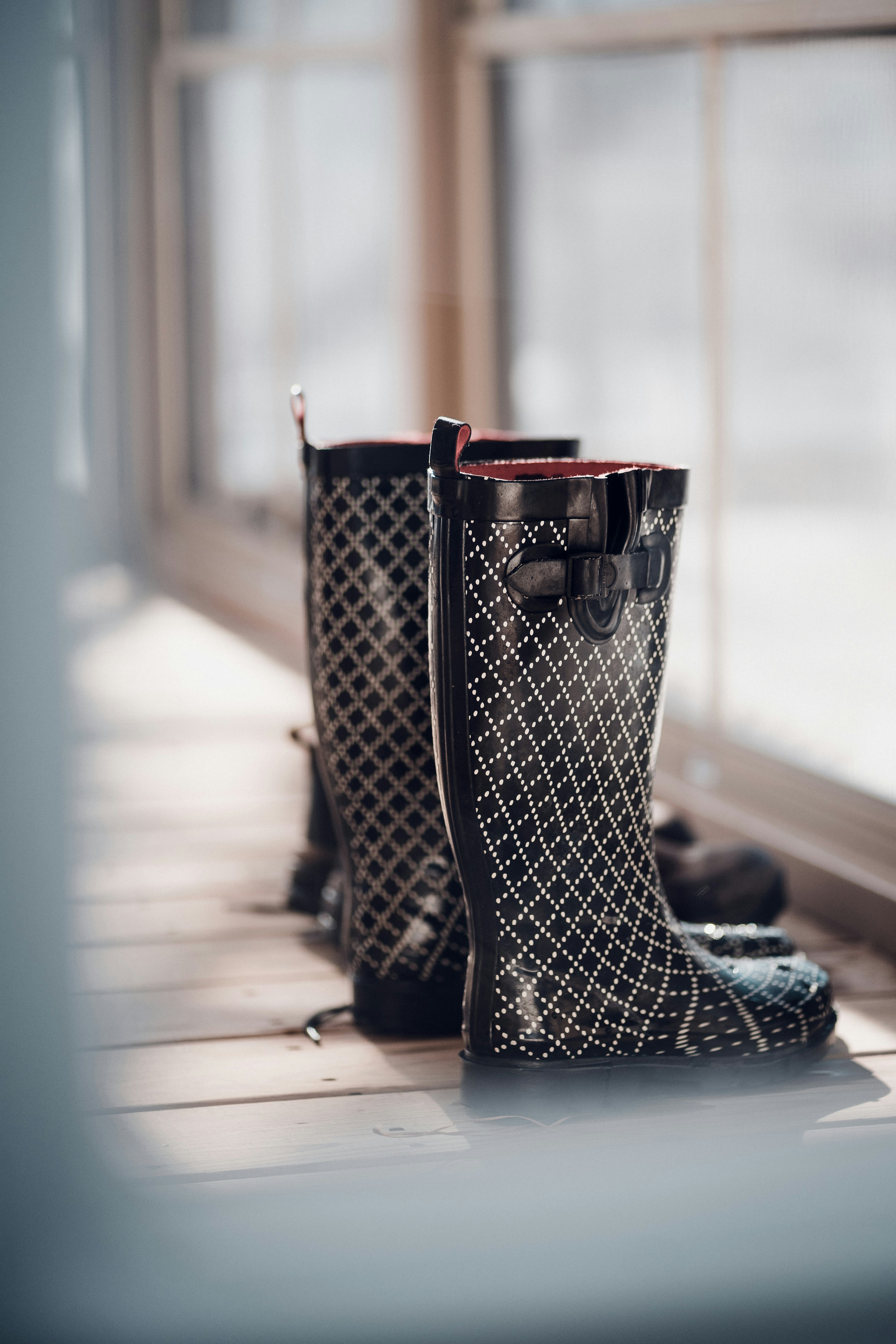 a pair of black boots sitting on top of a window sill