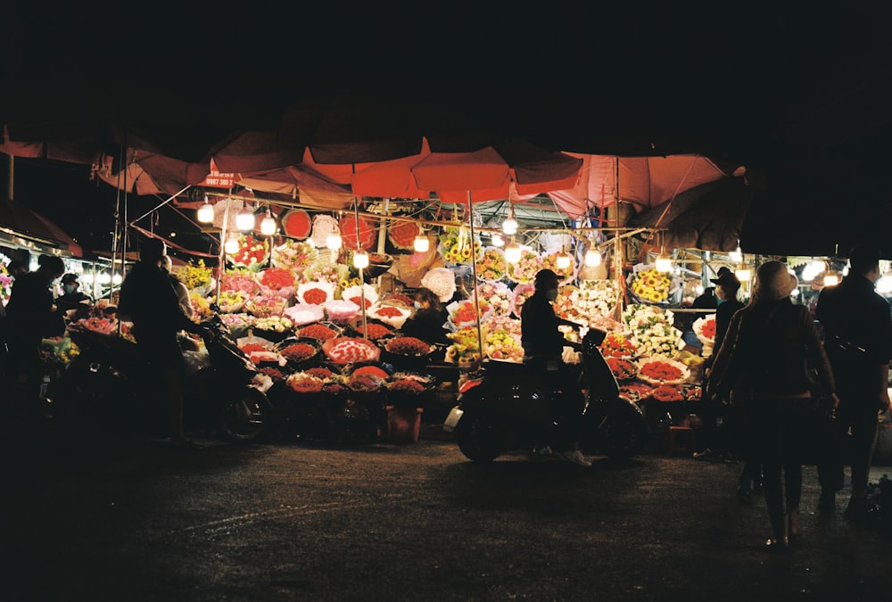 a group of people standing in front of a fruit stand