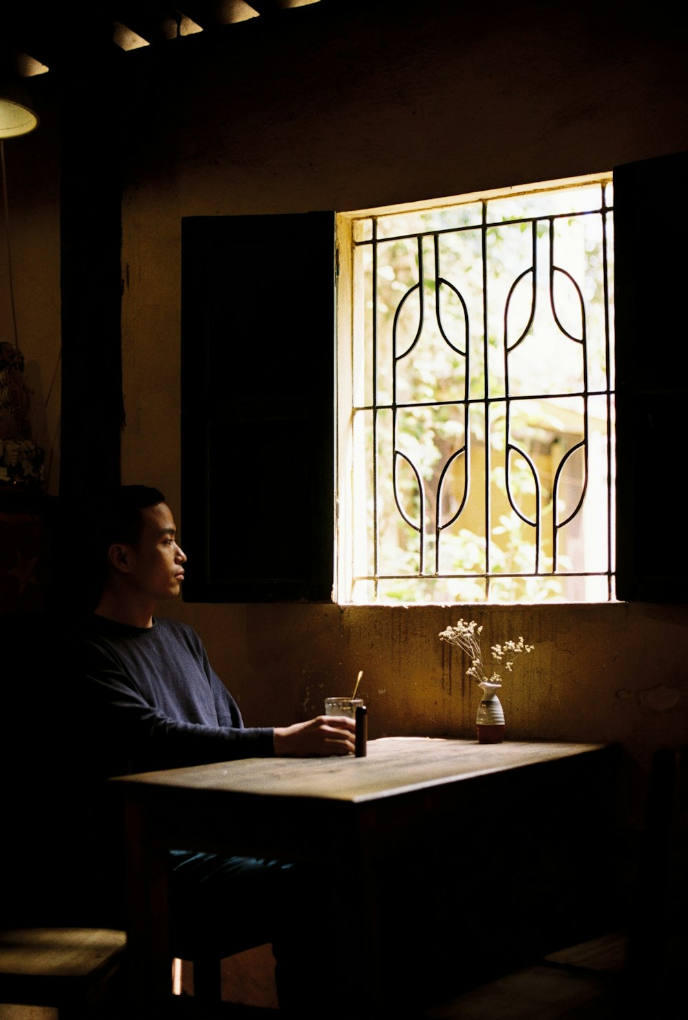 a man sitting at a table in front of a window