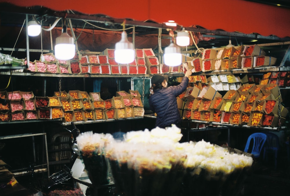 a man standing in front of a store filled with lots of food