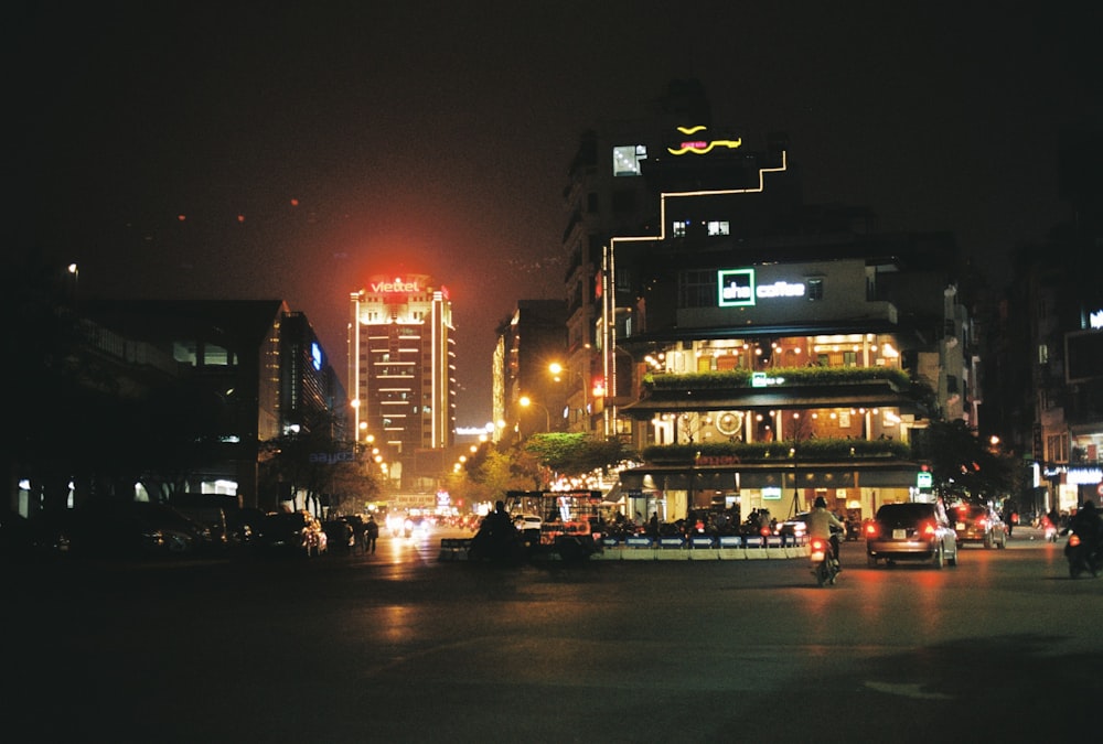 Eine Stadtstraße bei Nacht mit Autos und Gebäuden