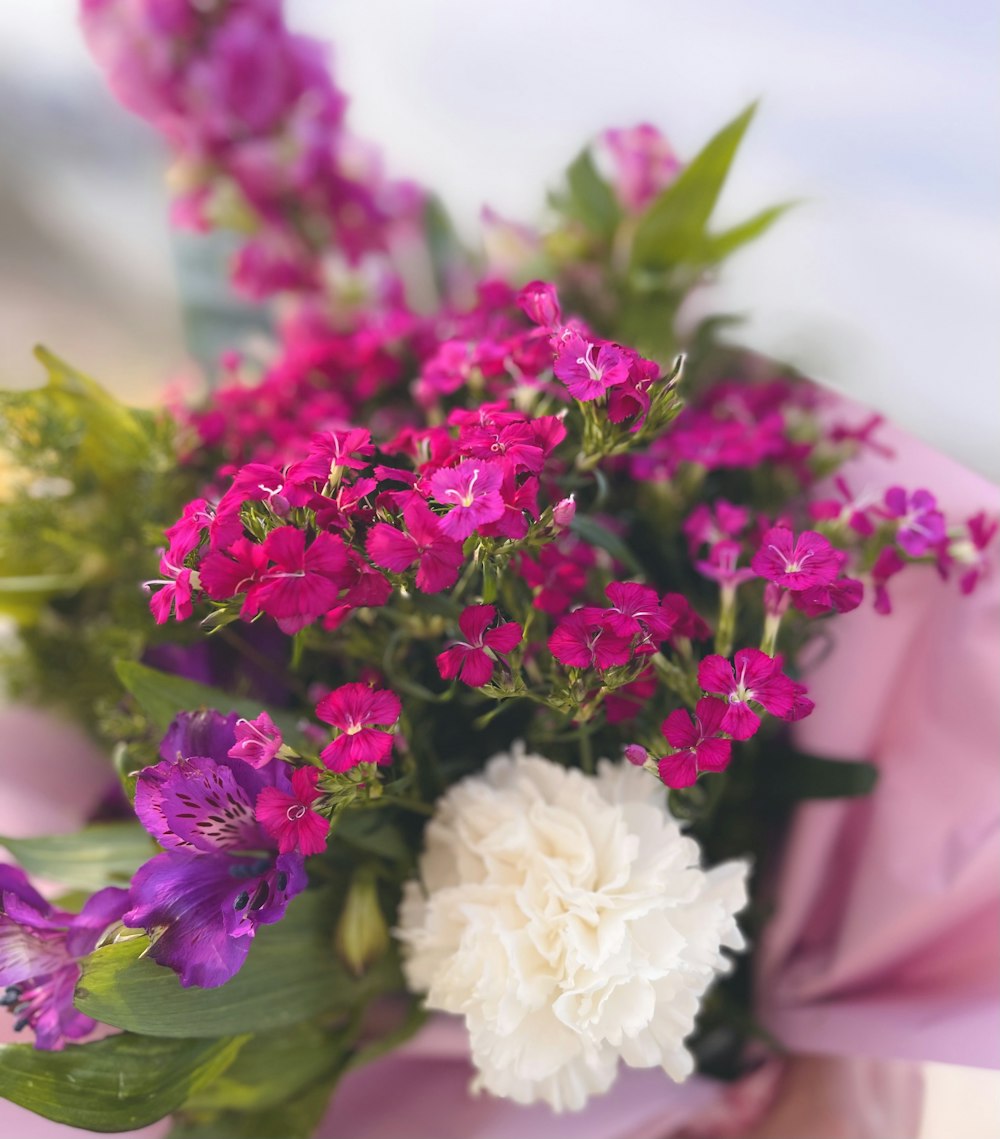 a bouquet of purple and white flowers in a vase