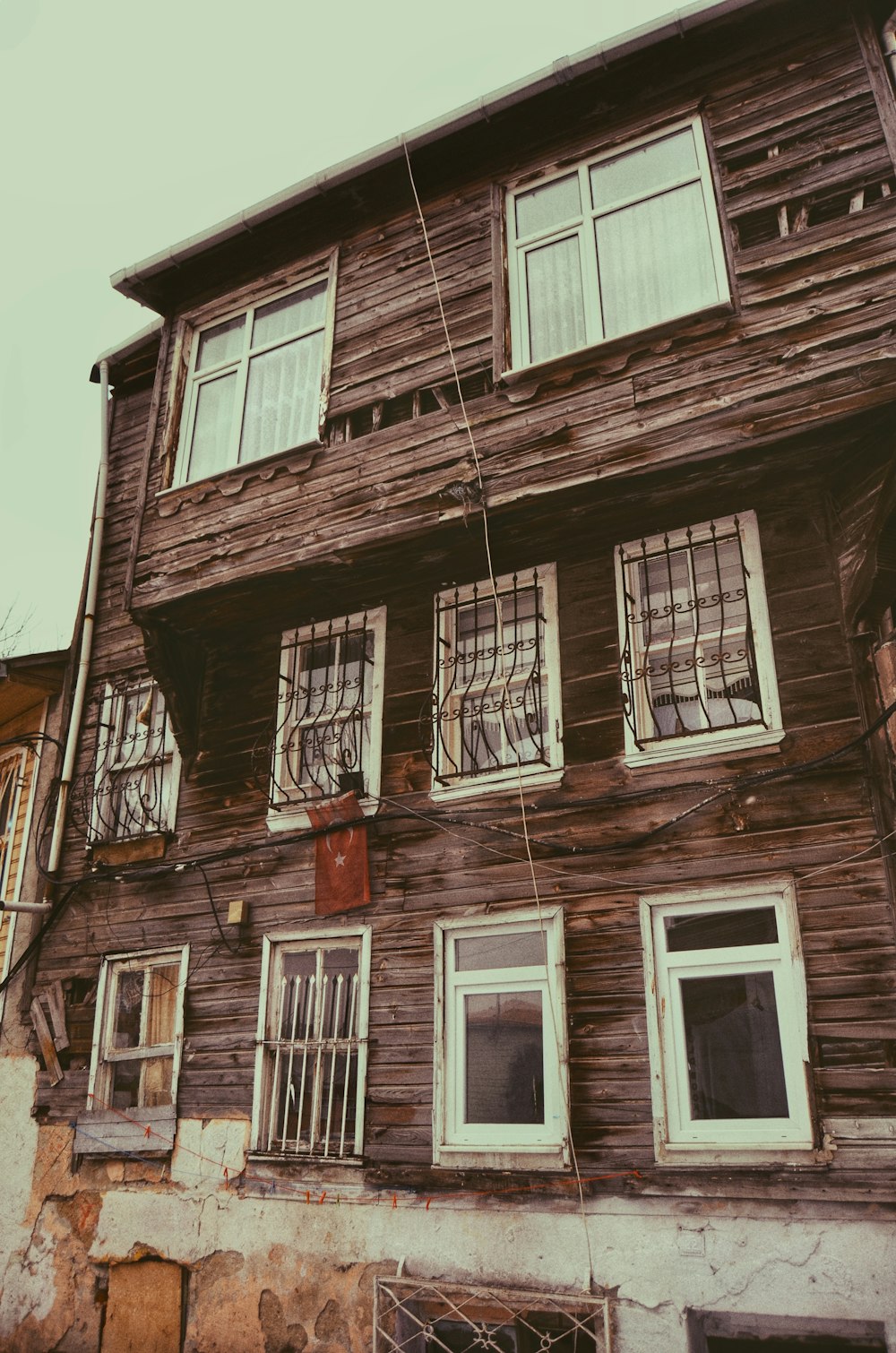 an old wooden building with windows and bars