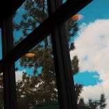 Close-up of a sparkling clean window reflecting a bright blue sky at a lakeside home.