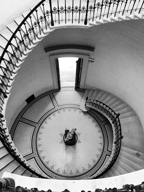 a spiral staircase with a clock in the center