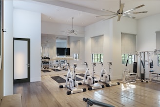 a gym with a ceiling fan and exercise equipment