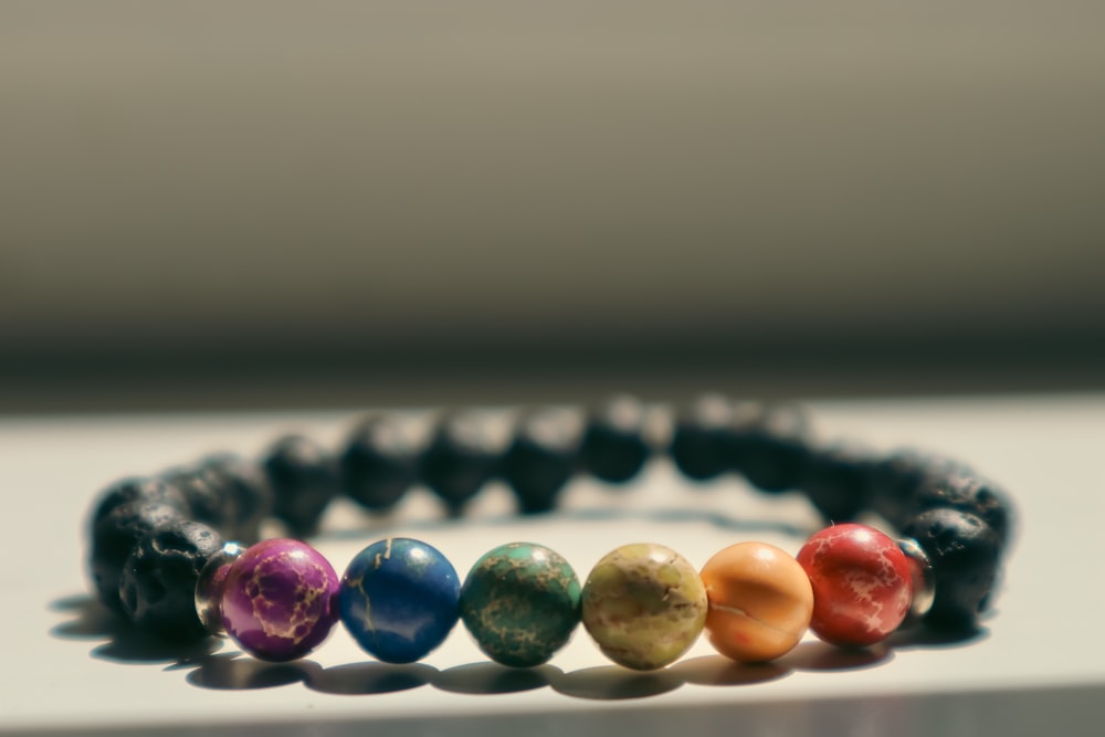 a bracelet with seven different colored beads on it