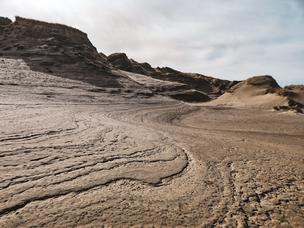 a sandy area with a mountain in the background