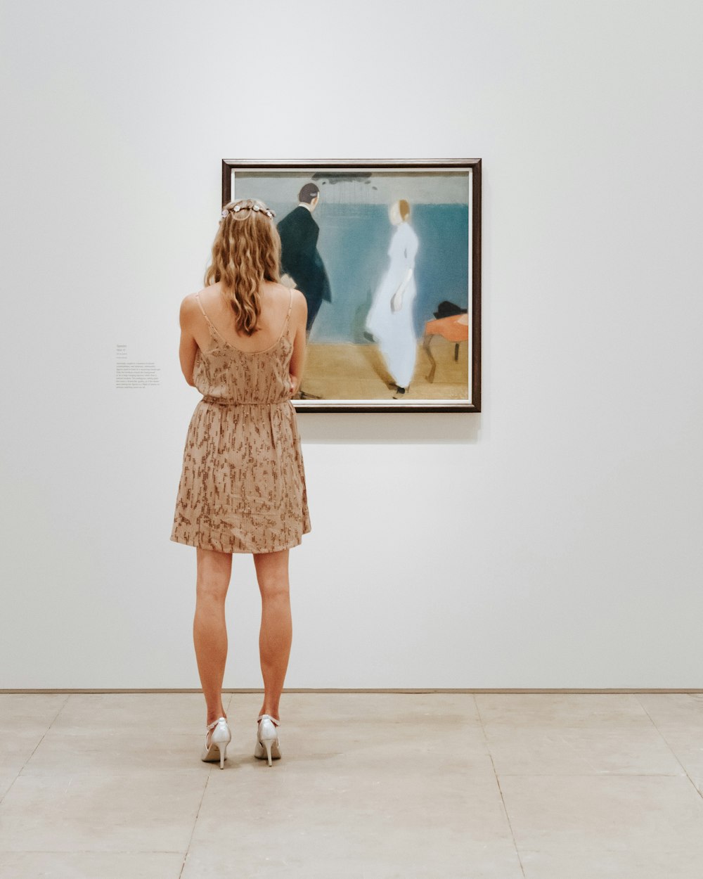 a woman looking at a painting in a museum