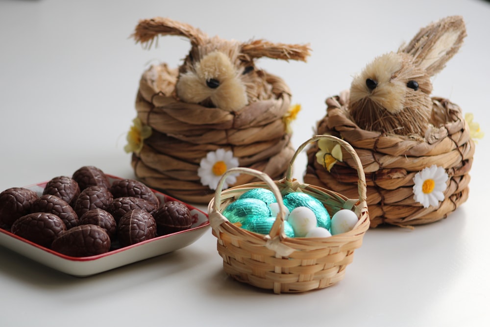 three small baskets filled with chocolate eggs and bunnies