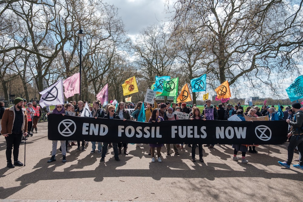 a group of people holding a banner with the words end fossil fuels now