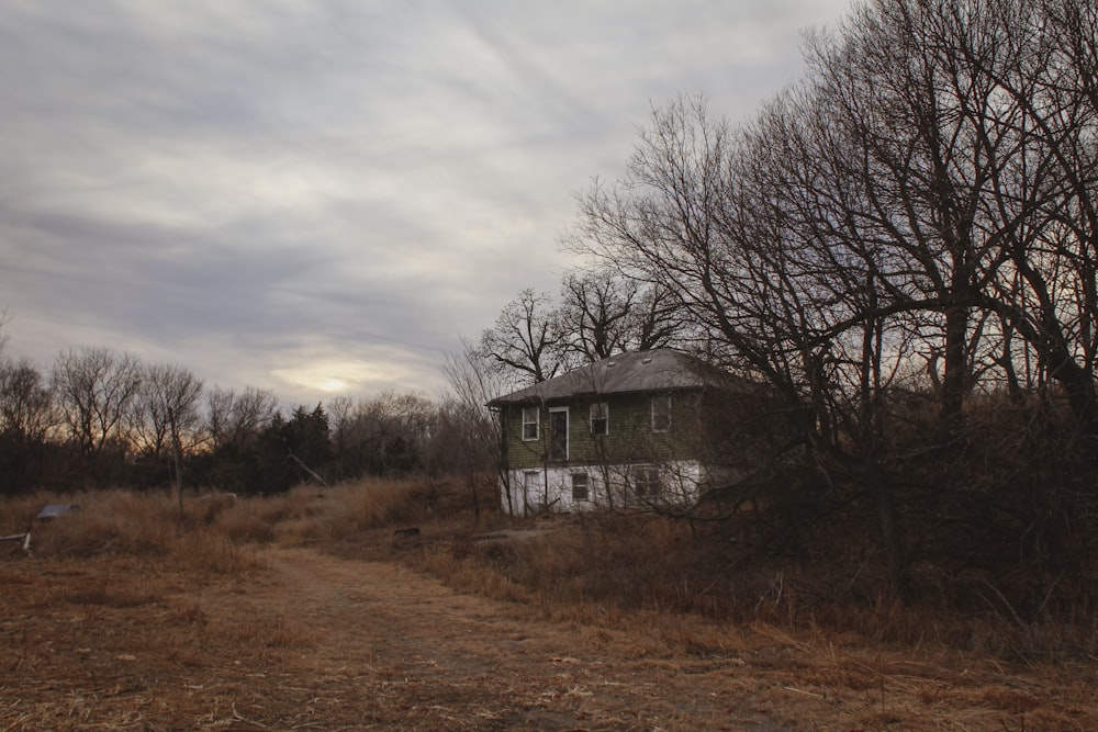 a run down house sitting in the middle of a field