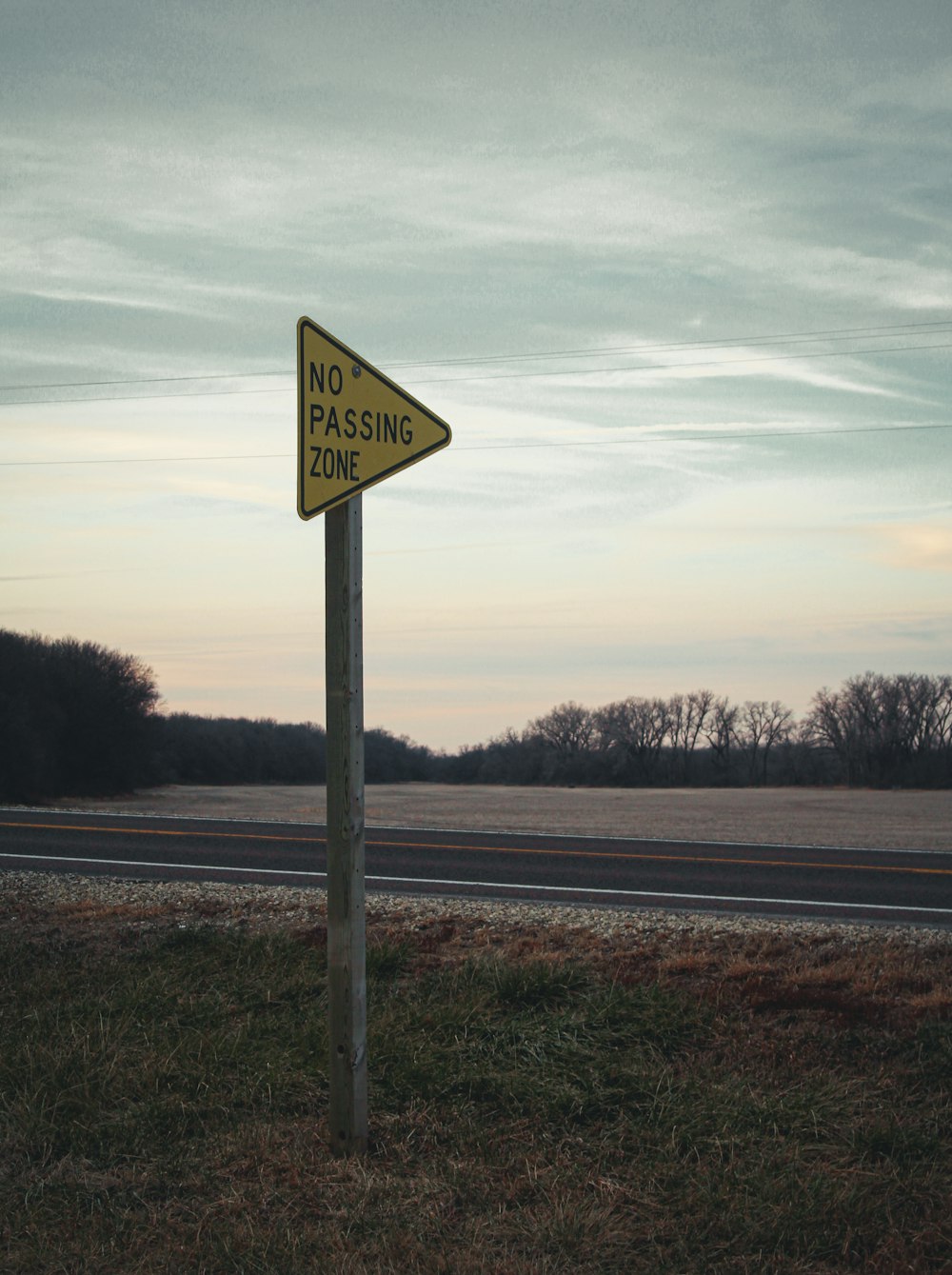 a no passing zone sign on the side of the road